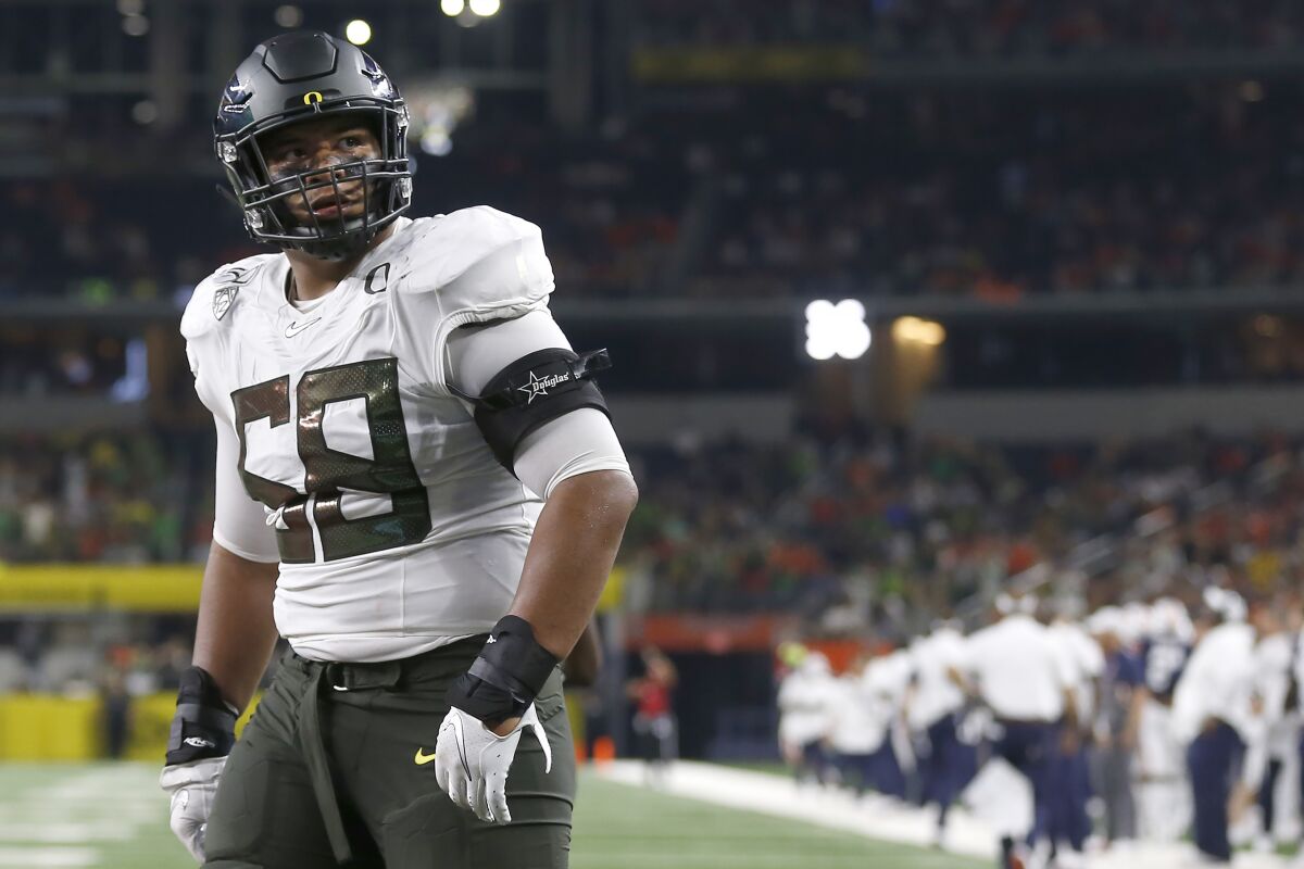 FILE - In this Aug. 31, 2019, file photo, Oregon offensive lineman Penei Sewell (58) looks on as Oregon plays Auburn in an NCAA college football game in Arlington, Texas. After the Power Five conference commissioners met Sunday, Aug. 9, 2020, to discuss mounting concern about whether a college football season can be played in a pandemic, players took to social media to urge leaders to let them play. to discuss mounting concern about whether a college football season can be played in a pandemic, players took to social media to urge leaders to let them play. (AP Photo/Ron Jenkins, File)