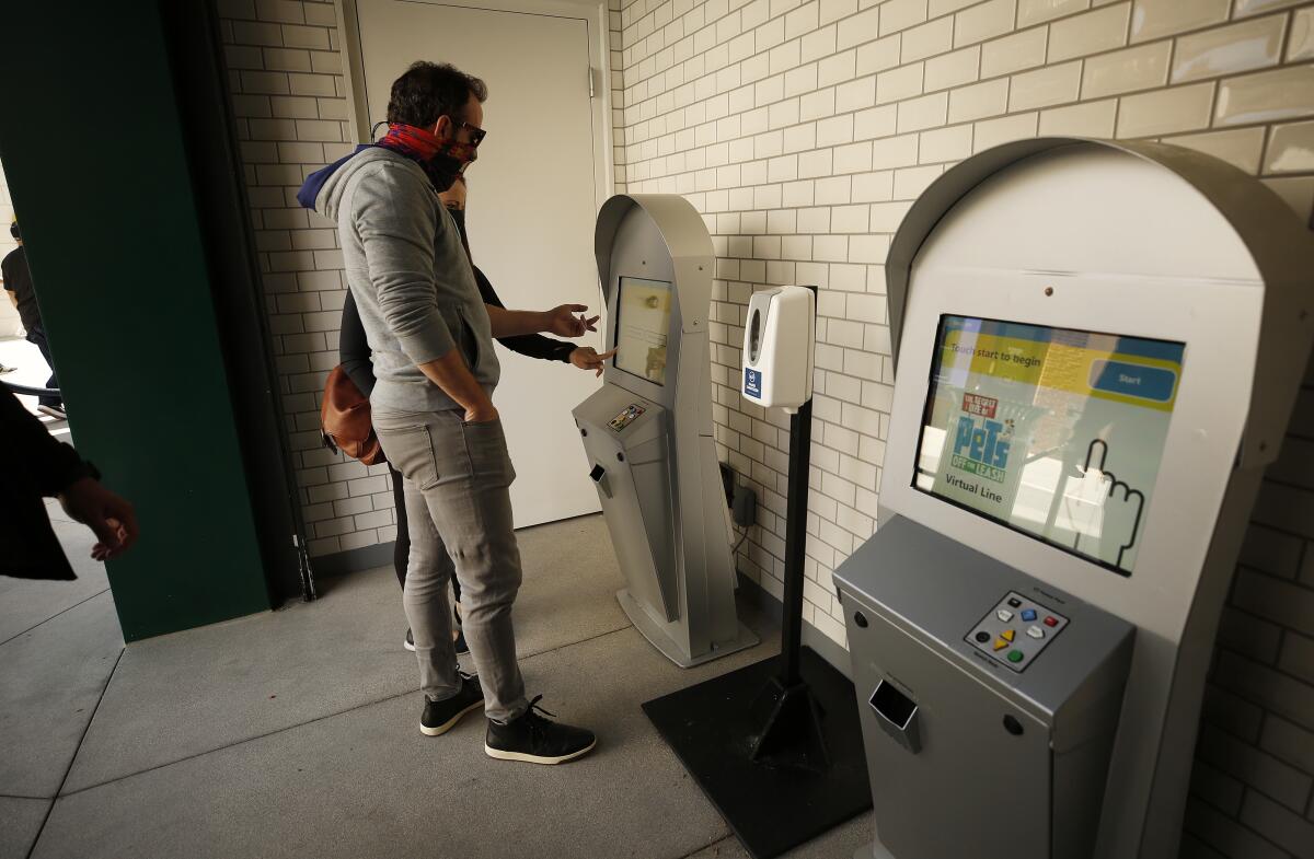 Universal Studios Hollywood visitors use a virtual-line kiosk.