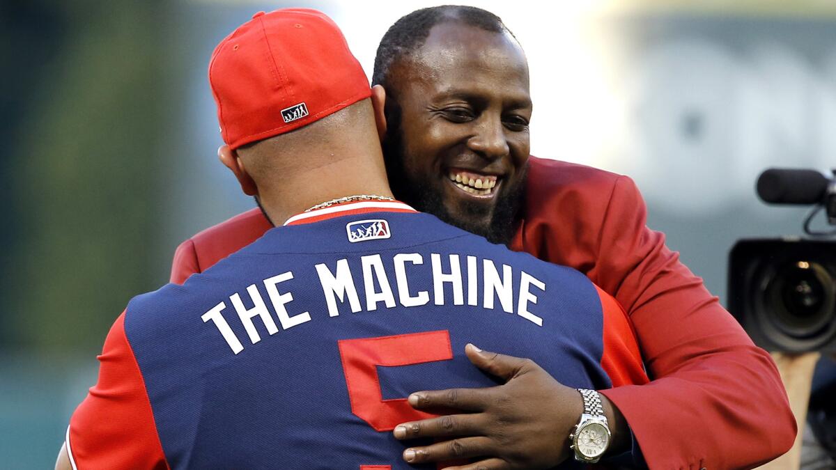 Vladimir Guerrero gets a hug from Angels designated hitter Albert Pujols during Guerrero's induction ceremony into the Angels' Hall of Fame on Saturday.