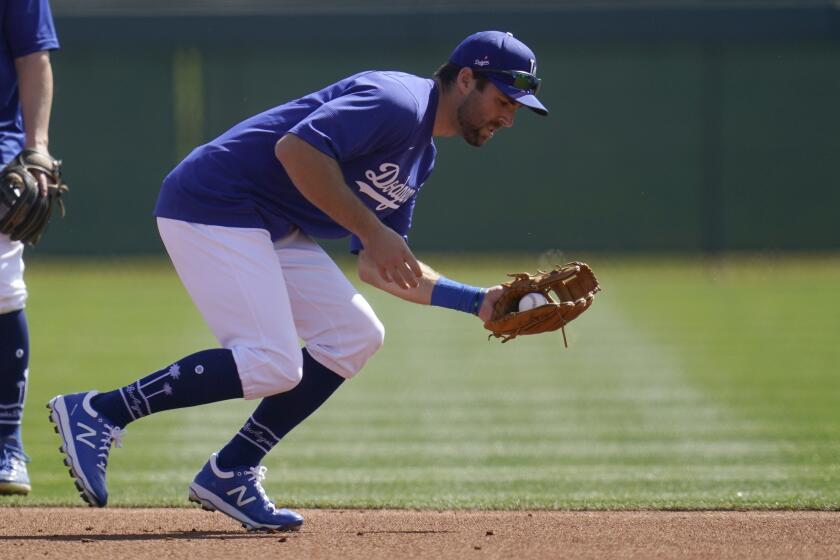 Los Angeles Dodgers second baseman Chris Taylor fields a grounder during a spring training baseball practice Tuesday, Feb. 23, 2021, in Phoenix. (AP Photo/Ross D. Franklin)