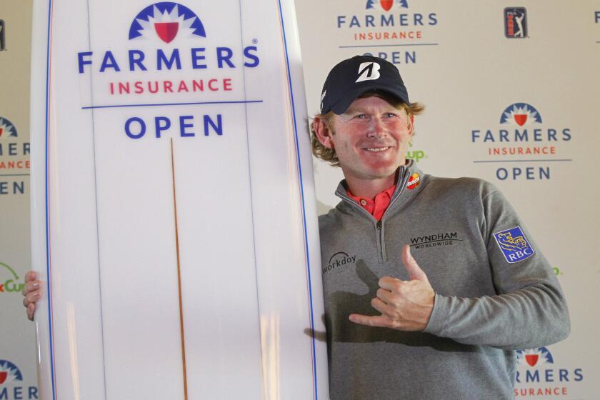 Brandt Snedeker poses with the surfboard awarded after he won the Farmers Insurance Open at Torrey Pines.