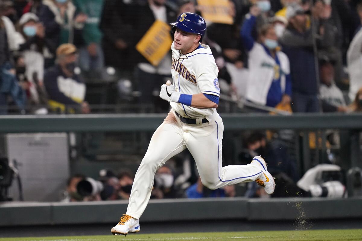 Seattle Mariners' Jarred Kelenic heads home to score against the Los Angeles Angels in the second inning of a baseball game Sunday, Oct. 3, 2021, in Seattle. (AP Photo/Elaine Thompson)