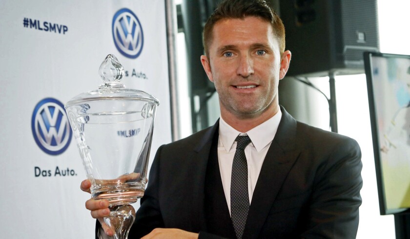 Galaxy forward Robbie Keane displays his trophy after he was honored as Major League Soccer's MVP on Wednesday.