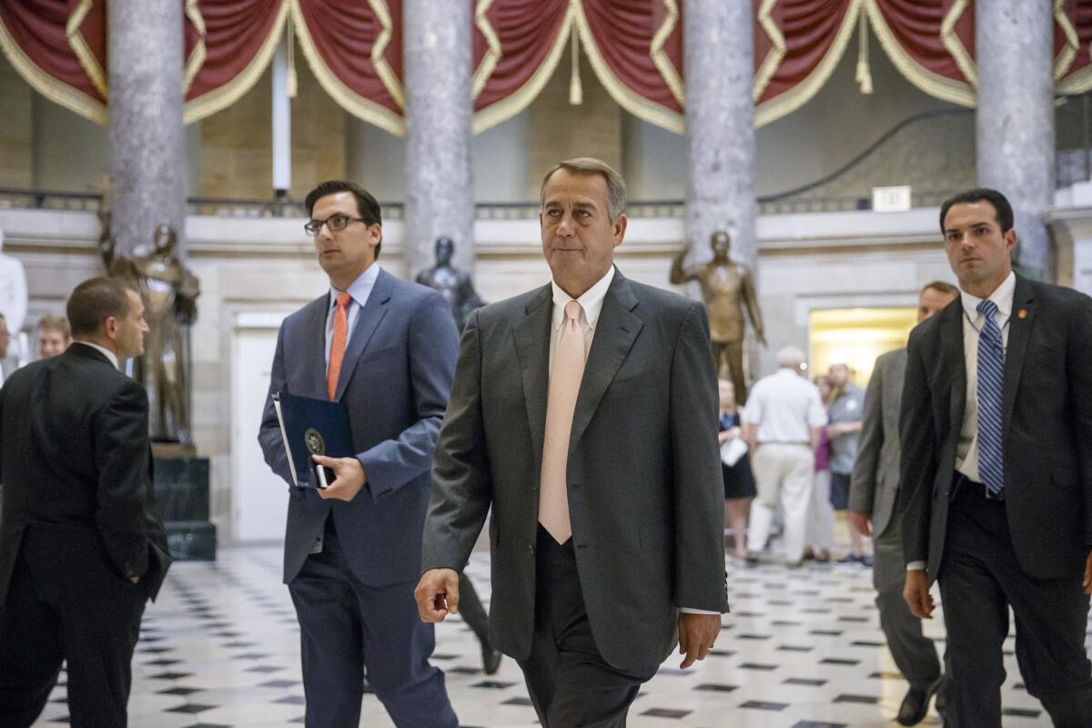 Speaker of the House John A. Boehner (R-Ohio), center, is shown Wednesday at the Capitol shortly before lawmakers voted to authorize a lawsuit against President Obama.