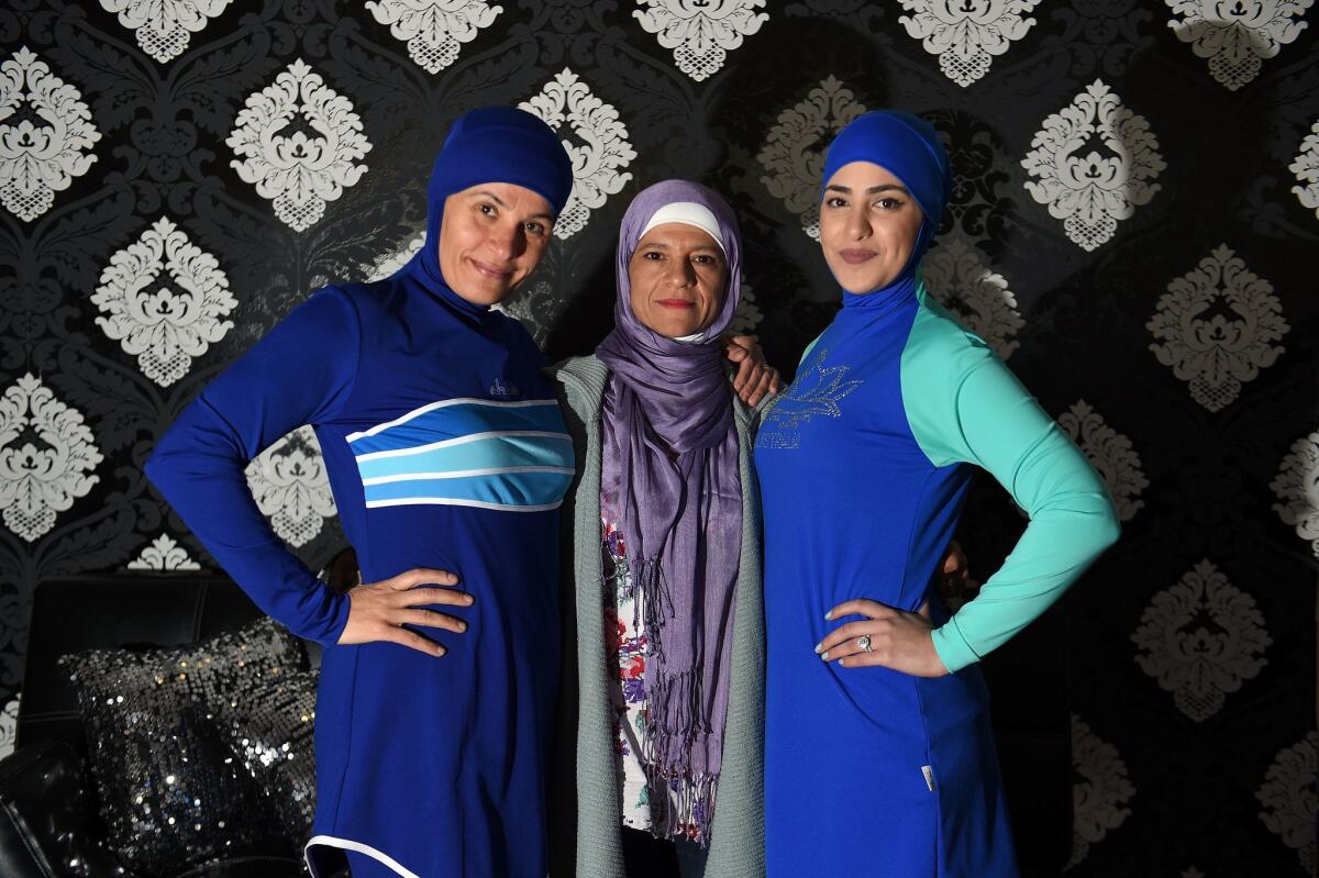 Models clad in burqini swimsuits pose for photos with Australian-Lebanese designer Aheda Zanetti, center, in western Sydney on Aug. 19, 2016. The light-weight, quick-drying two-piece swimsuit which covers the body and hair has been banned from French beaches by several mayors in recent weeks following deadly attacks linked to Islamic jihadists.
