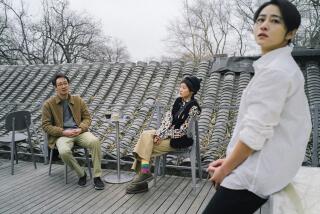 Three people have a discussion on a rooftop porch.