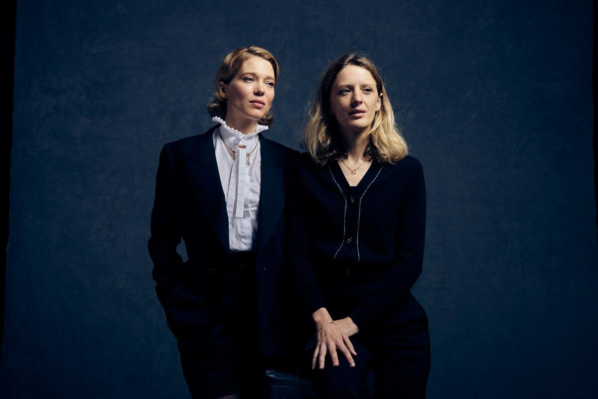 Actor Léa Seydoux and director Mia Hansen-Løve stand shoulder to shoulder looking to their left for a portrait.