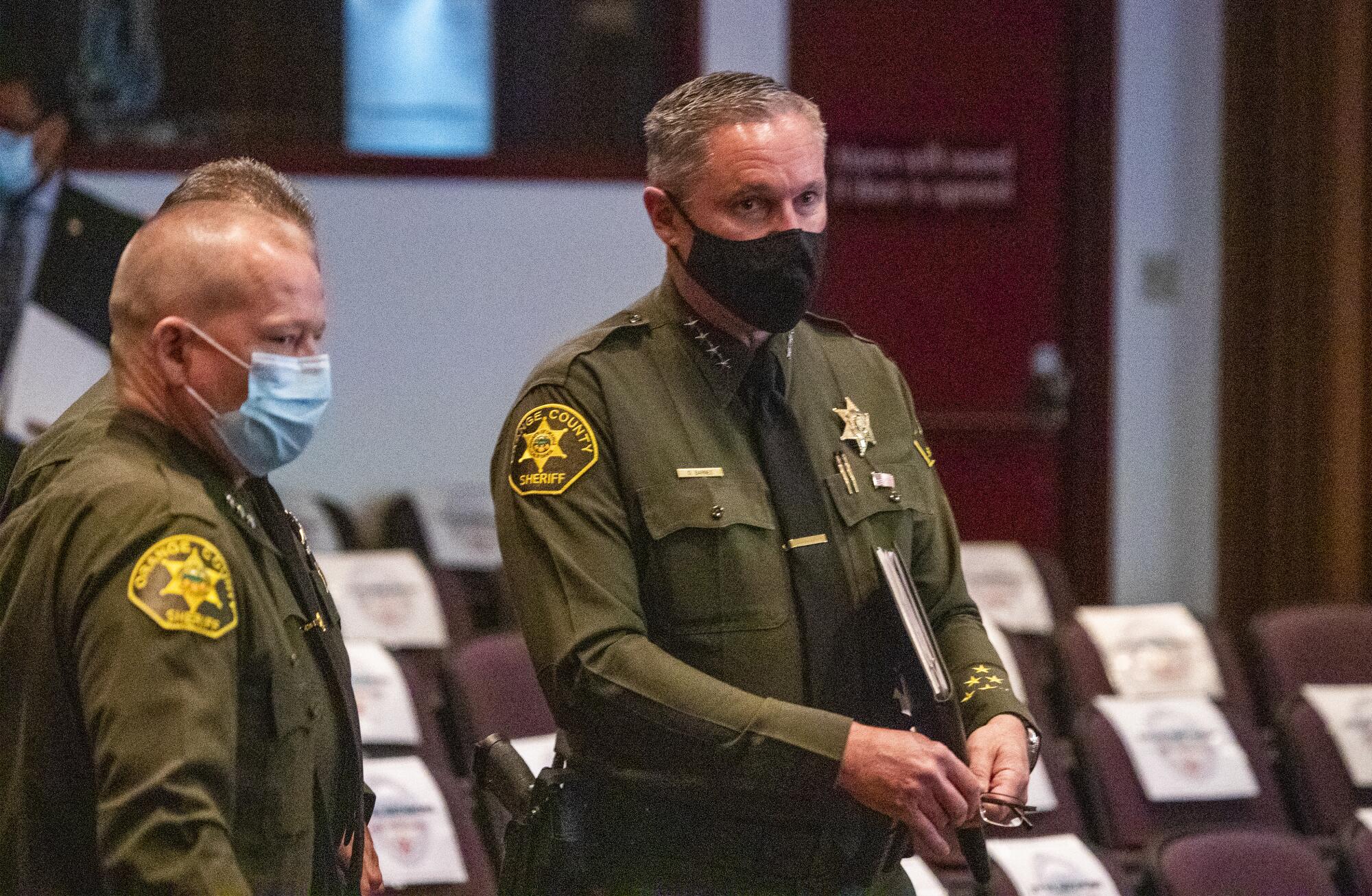 Orange County Sheriff Don Barnes, right, attends an Orange County Board of Supervisors meeting.