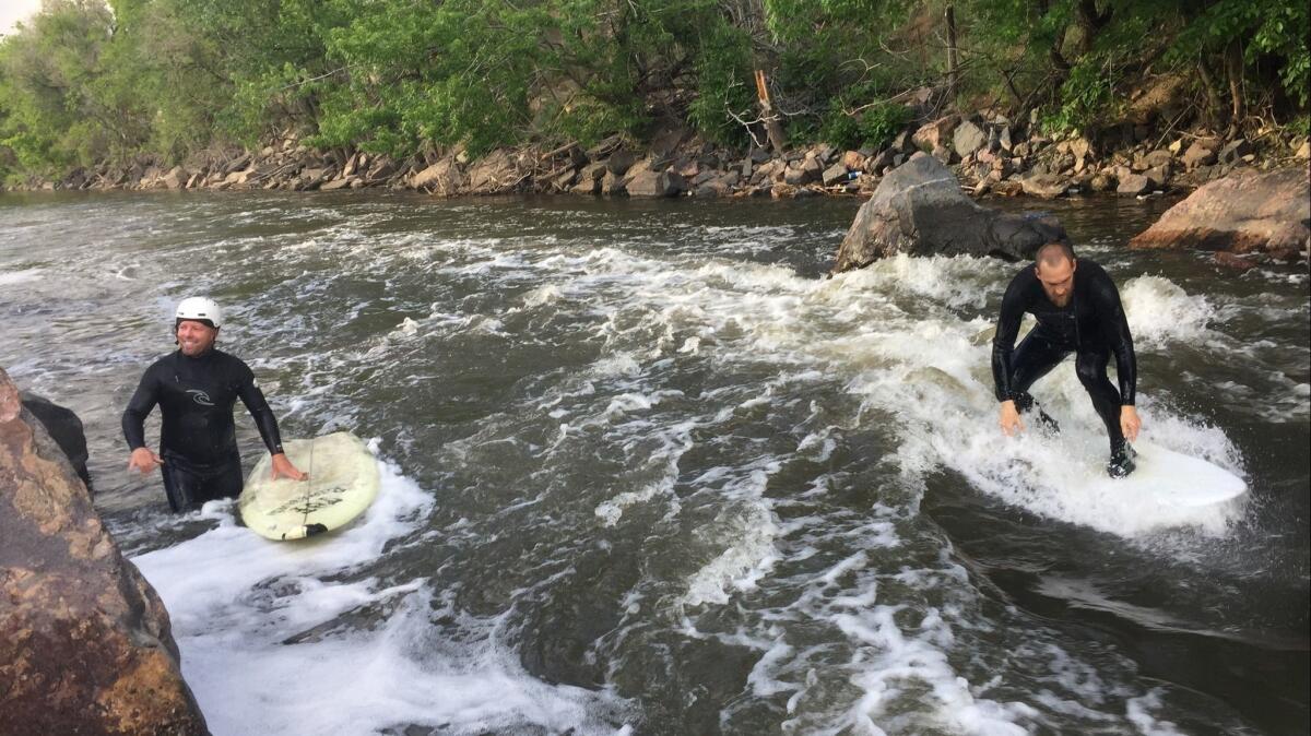 Eric Thomas, left, and Dan Setzke surfing the Beaver Wave in the South Platte River running through Denver.