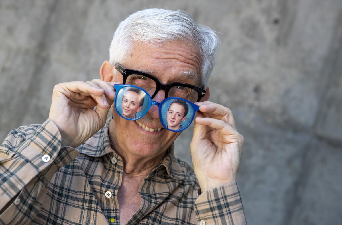 Fritz Coleman with an old pair of his signature large blue glasses with photos of his two boys, Corey and Kelsey.