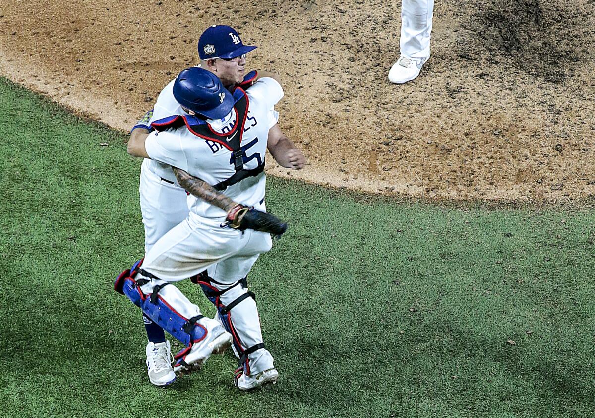Austin Barnes and Julio Urías embrace after the final out in Game 6 of the 2020 World Series at Globe Life Field. 