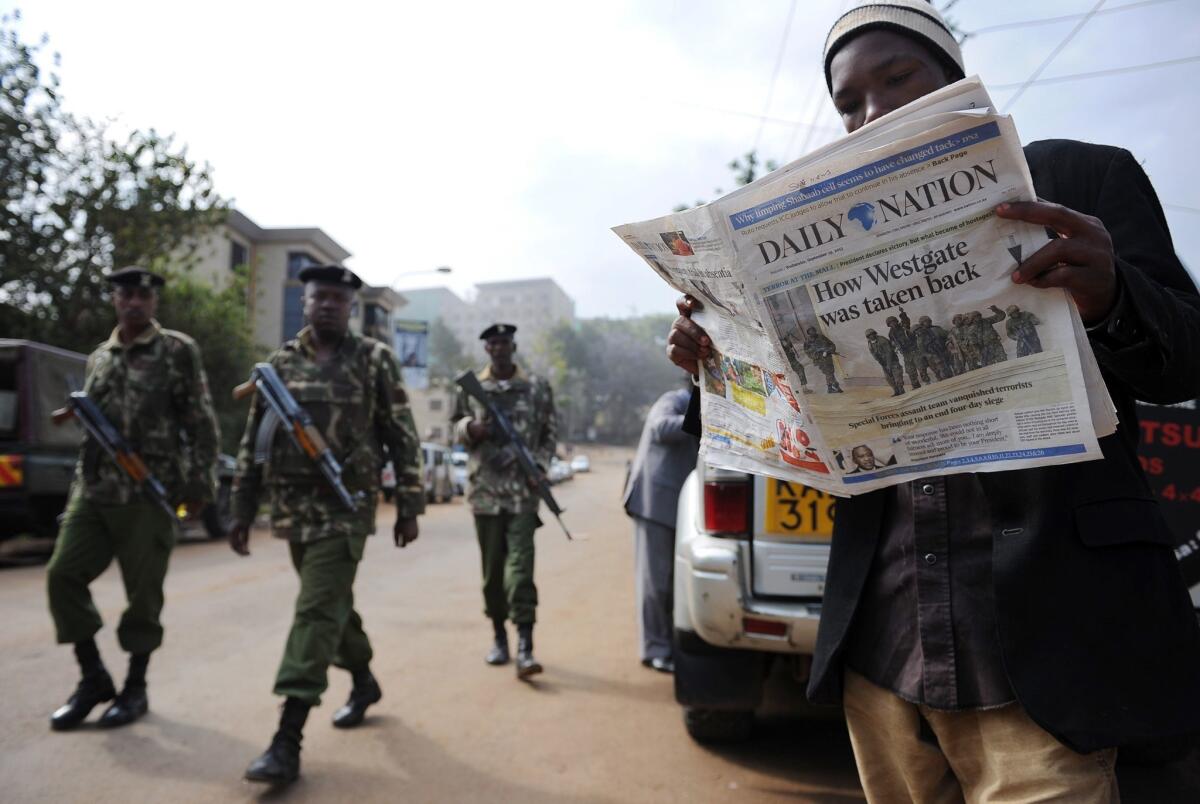 A man reads Wednesday's paper in Nairobi after Kenyan forces took back control of Westgate mall following a days-long siege that killed scores of people.