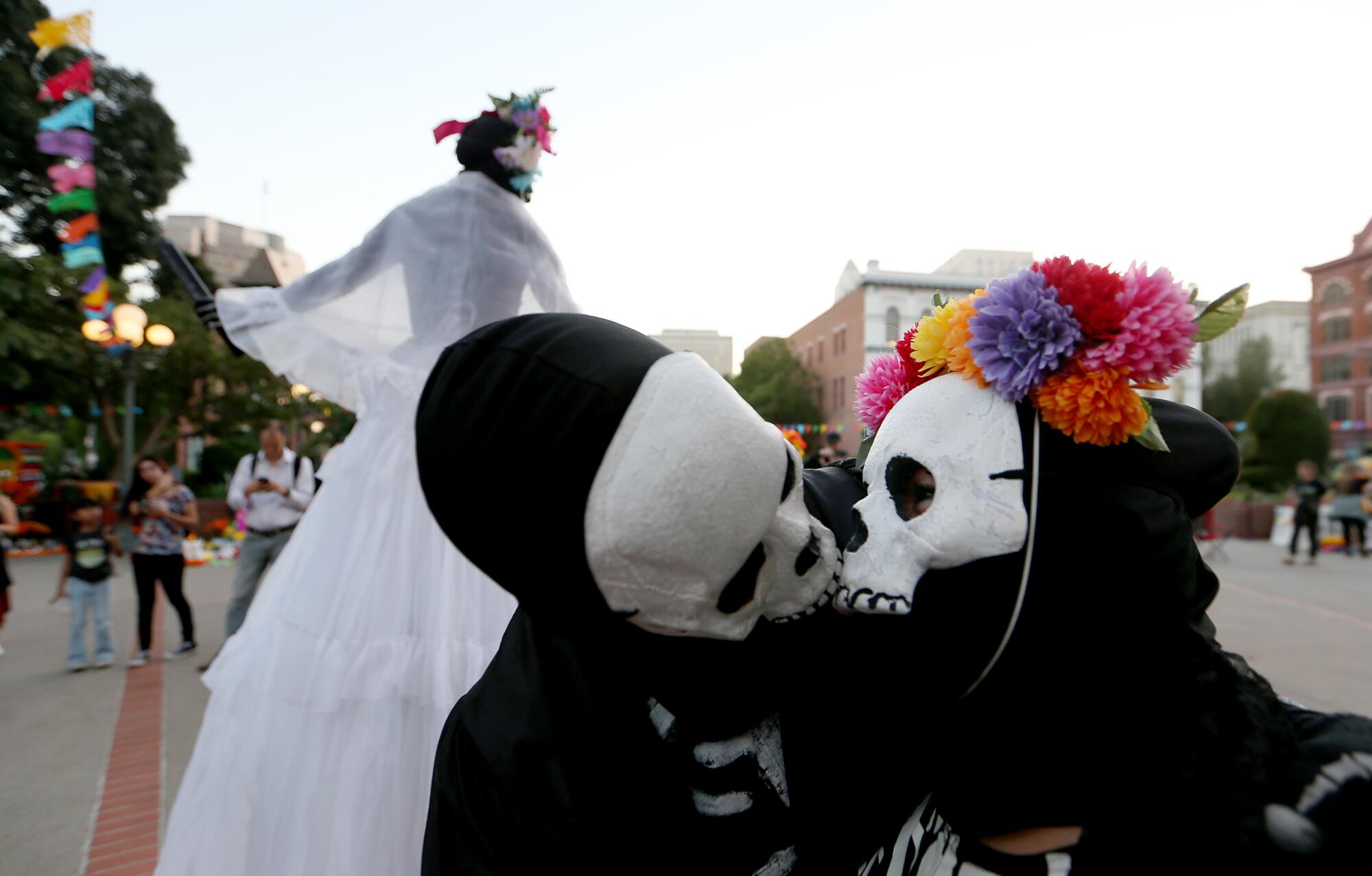 Skeletons share a kiss during Day of the Dead festivities at Olvera Plaza.