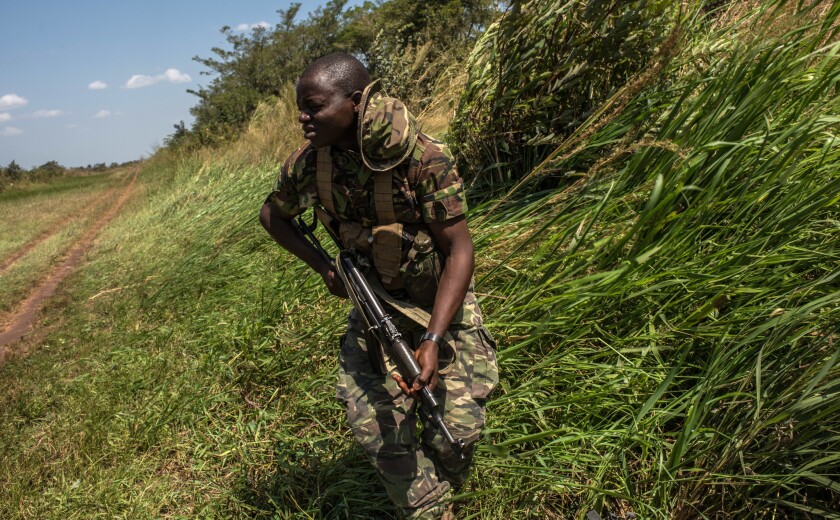 Wind generated from a helicopter blows in the direction of Ranger Mbolihumdole Uwele after being dropped just outside the Bagunda outpost in Garamba National Park.