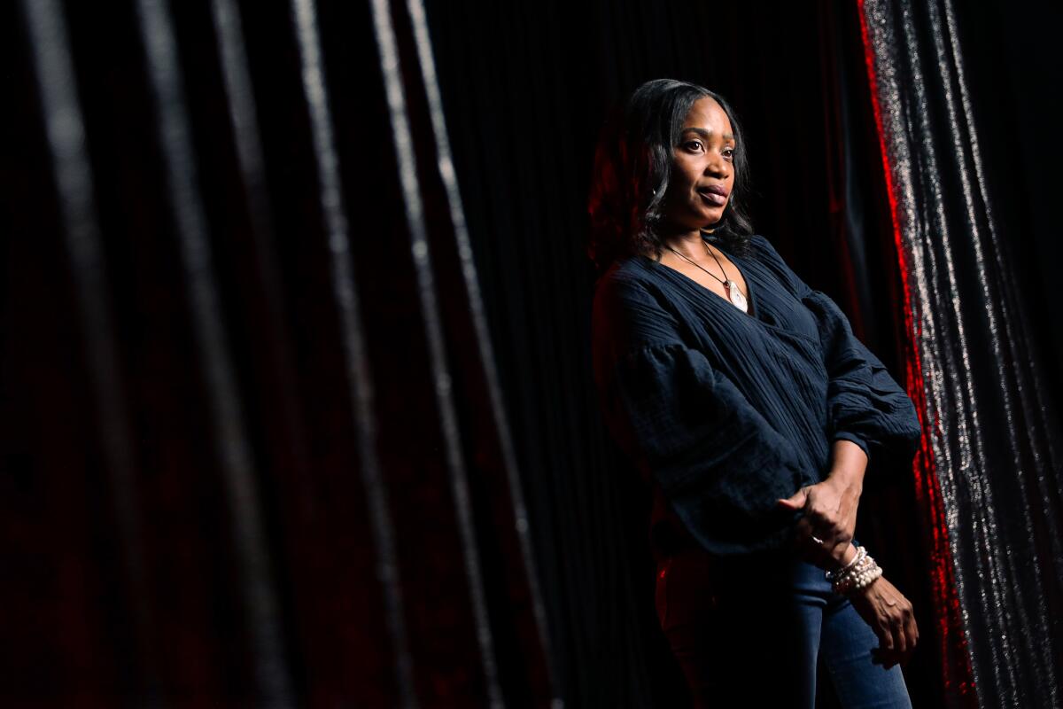 Woman standing in the light near curtains at the Comedy Store