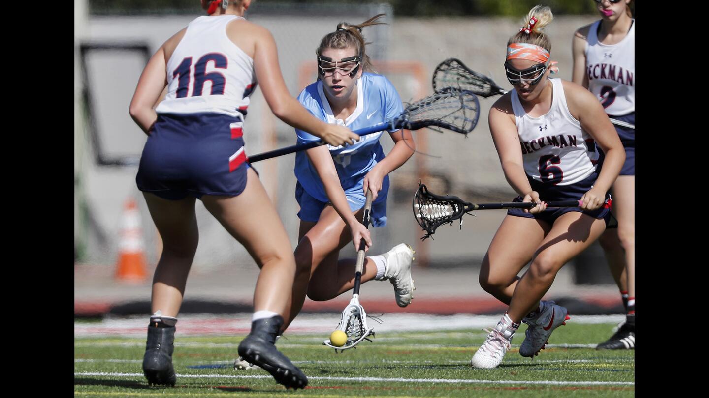 Corona del Mar High's Joslyn Simaan, center, collects a loose ball against Beckman during the first half in a Pacific Coast League game in Irvine on Wednesday, April 11.
