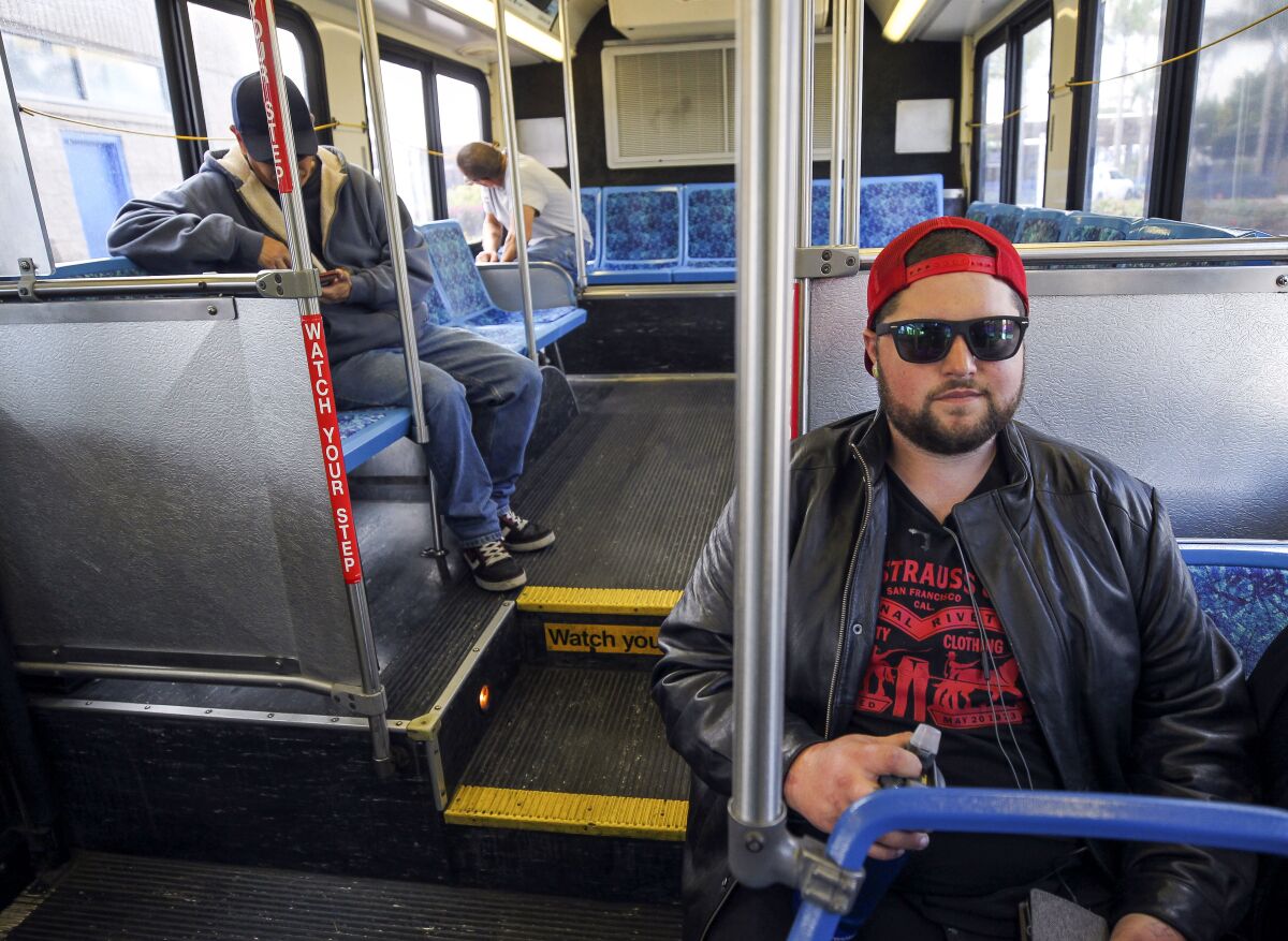 Anthony Egkert, right, who is on his way to work, sits on a NCTD Breeze bus just before it leaves from the Oceanside Transit Center on Saturday.