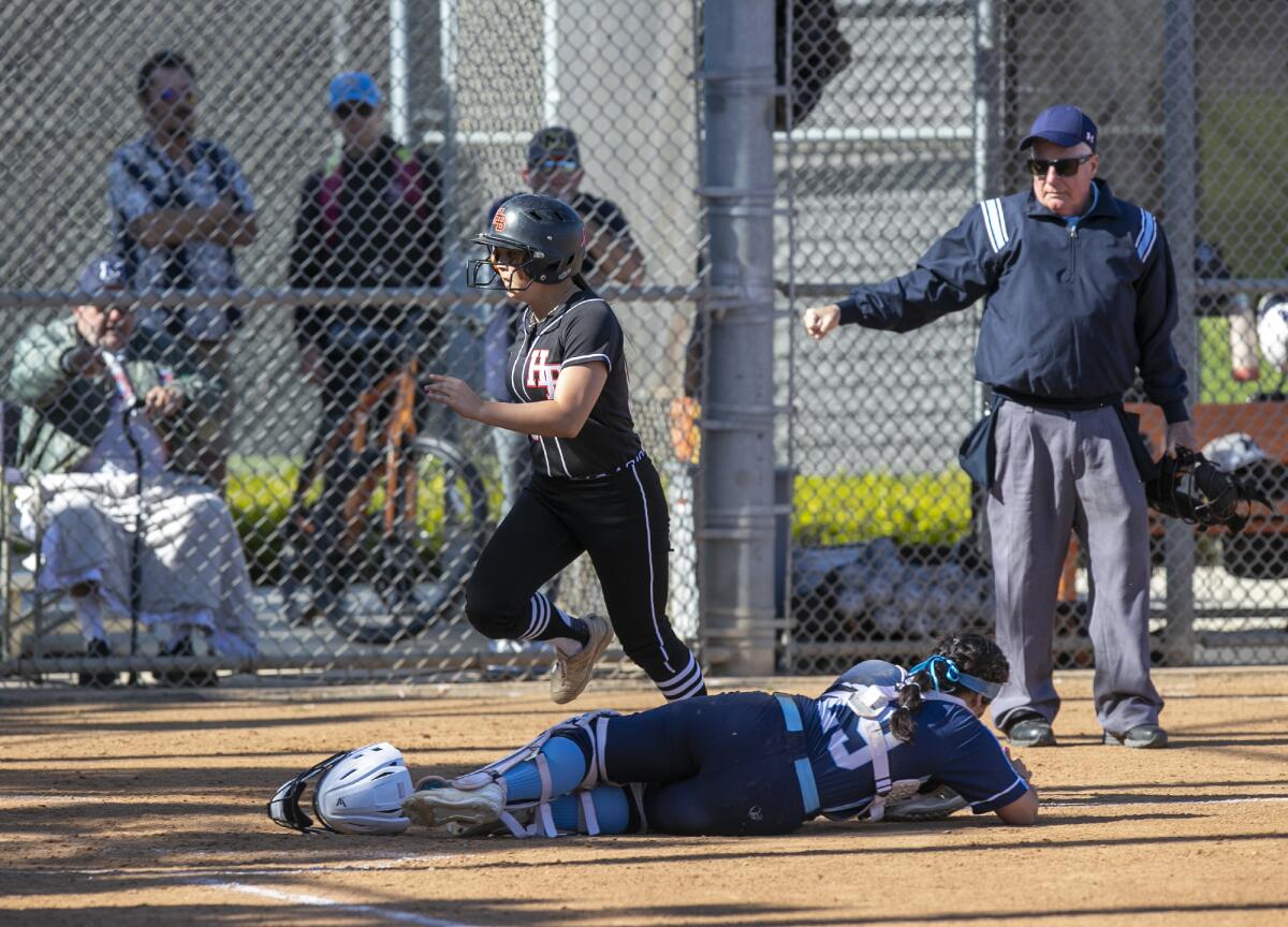 Huntington Beach's Ashley Long scores on a double by Saige Anderson in the third inning.