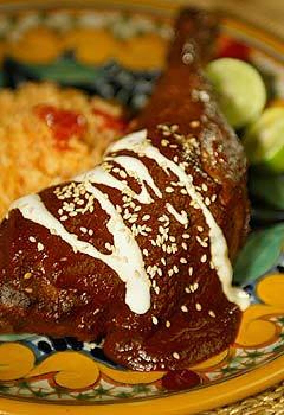 The classic mole poblano is made with turkey, shown here garnished with sesame seeds and Mexican crema.
