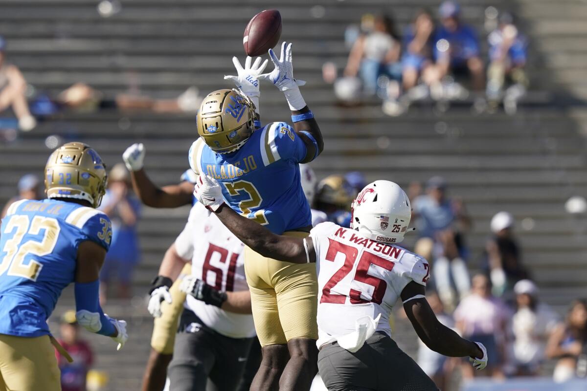 Le secondeur de l'UCLA, Oluwafemi Oladejo, intercepte une passe lancée par le quart-arrière de l'État de Washington, Cameron Ward. 