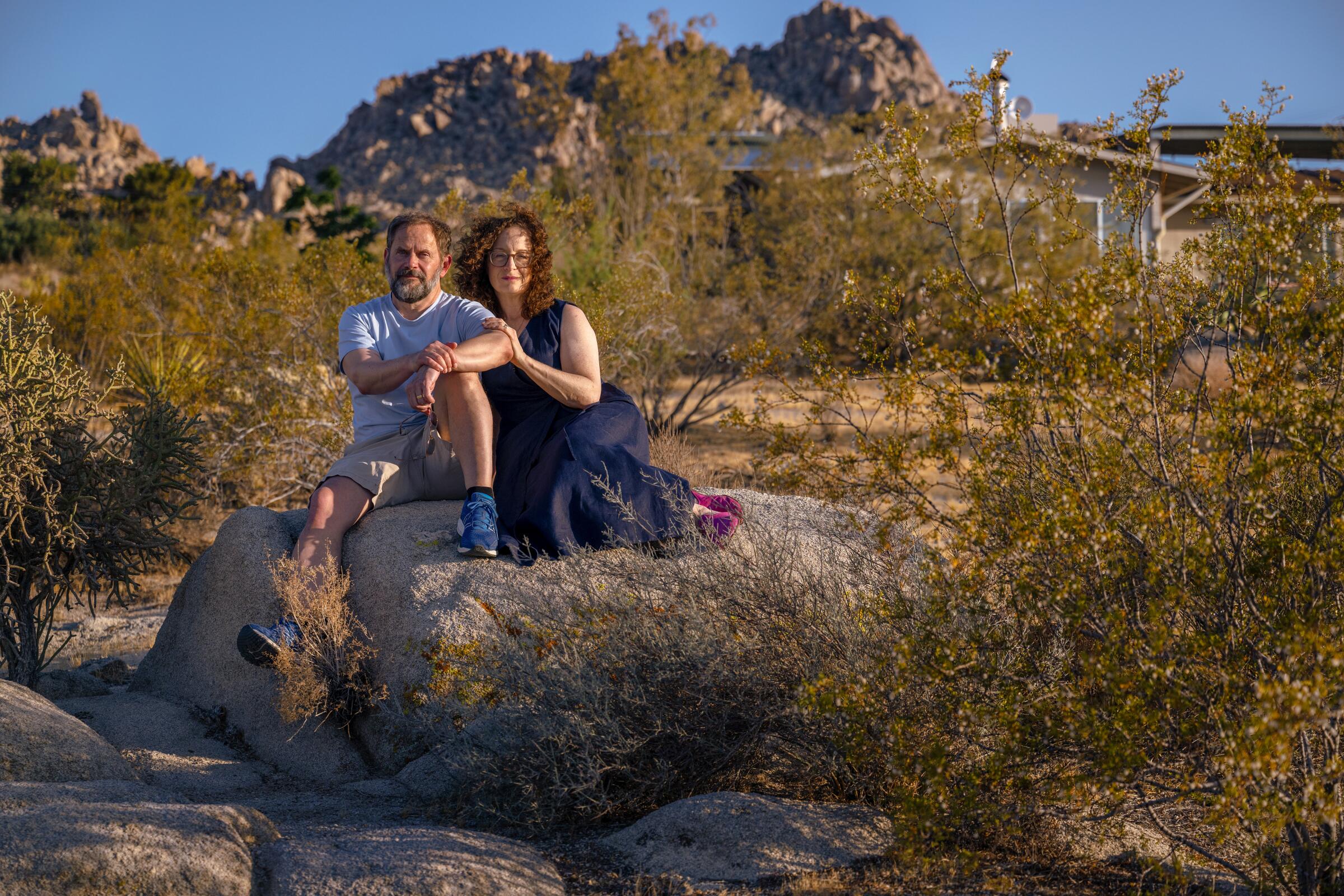 Colin Campbell and his wife, Gail Lerner, sitting on a rock in Joshua Tree.