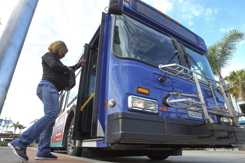 A woman boards a NCTD Breeze bus.