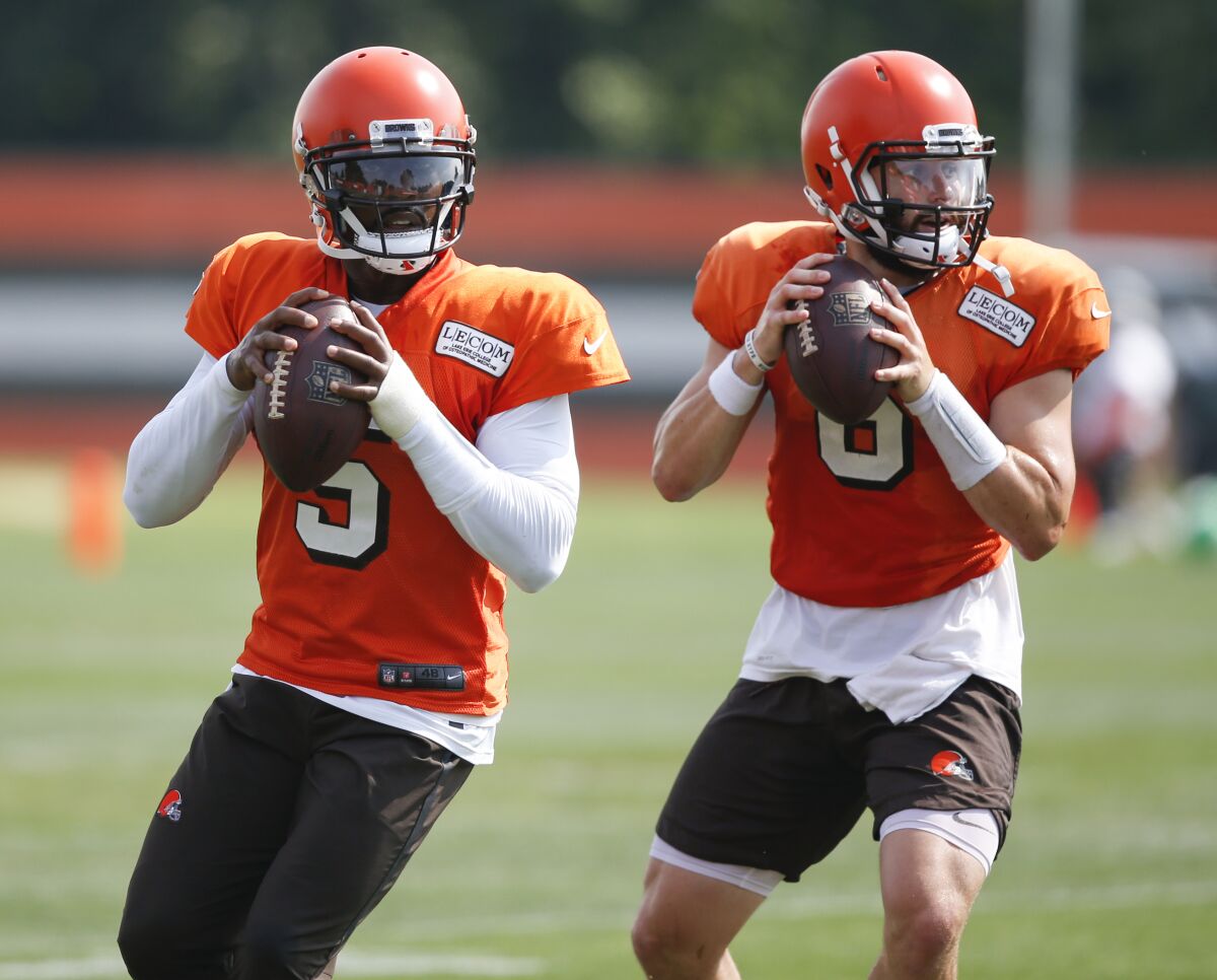 FILE - In this Aug. 27, 2018, file photo, Cleveland Browns quarterbacks Tyrod Taylor (5) and Baker Mayfield (6) throw during NFL football practice in Berea, Ohio. When Cleveland fans fill FirstEnergy Stadium on Sunday for the first time in nearly two years, they'll see several familiar faces on Houston's roster, including Taylor, who was briefly the Browns' starter when Mayfield was a rookie in 2018. (AP Photo/Ron Schwane)