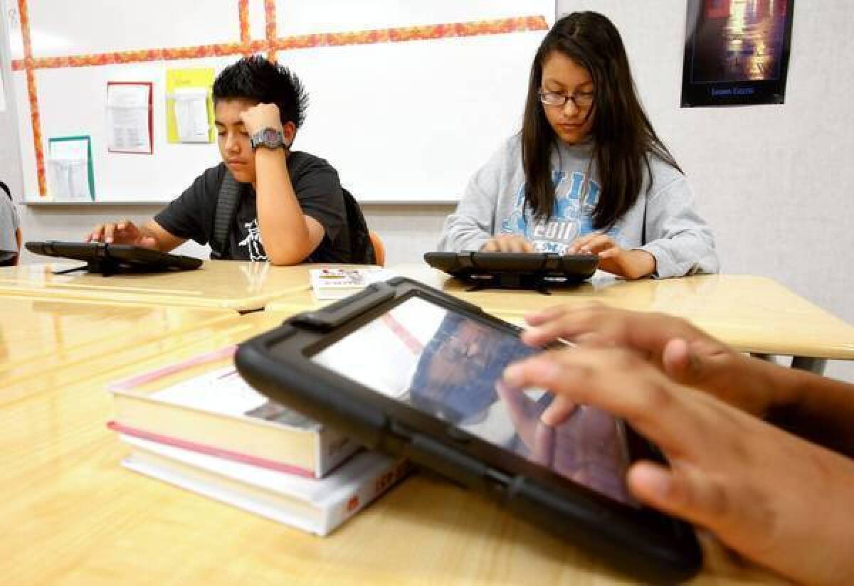 Bryan Acevedo, 15, and Elizabeth Varela, 14, along with other students, use their iPads while working on an assignment in their ninth-grade English class at Valley Academy of Arts and Sciences in Granada Hills, one of the first L.A. Unified schools to provide students with iPads under a pilot program.