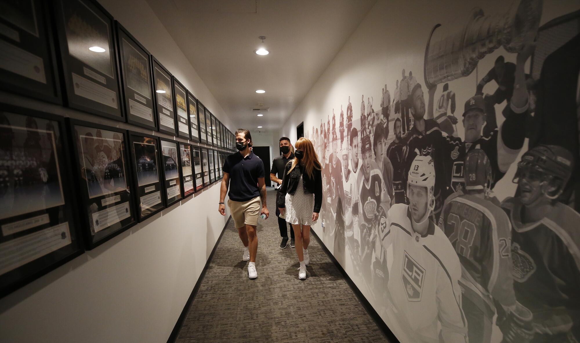 Los Angeles Kings new player Phillip Danault and his wife Marie-Pierre Danault walk past historic photographs