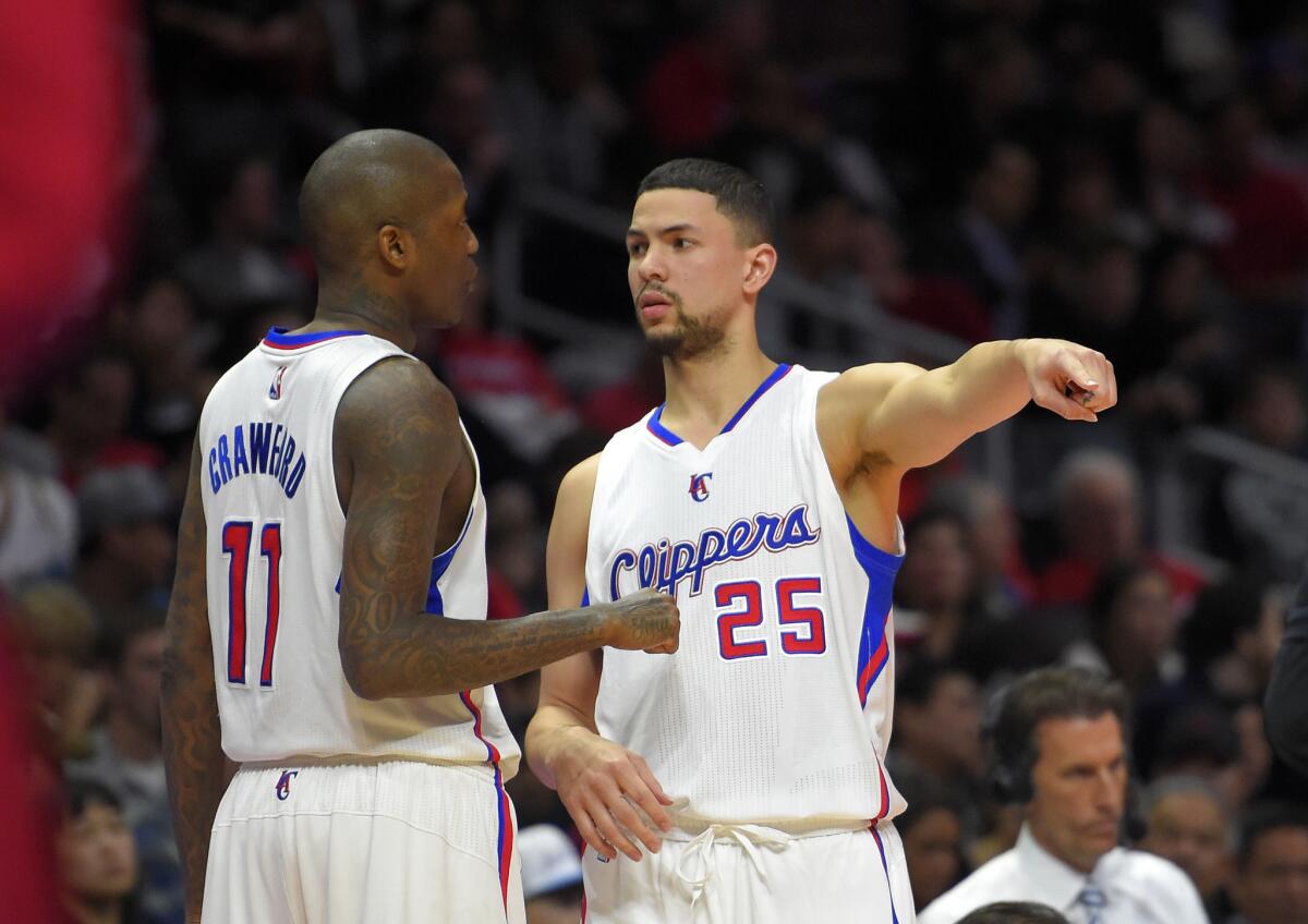 Jamal Crawford talks with Austin Rivers, right, during the first half of a game against the Cleveland Cavaliers on Jan. 16 at Staples Center.