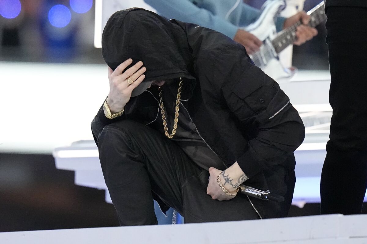 Eminem kneels down during the halftime performance at the NFL Super Bowl 56 football game between the Los Angeles Rams and the Cincinnati Bengals Sunday, Feb. 13, 2022, in Inglewood, Calif. (AP Photo/Chris O'Meara)