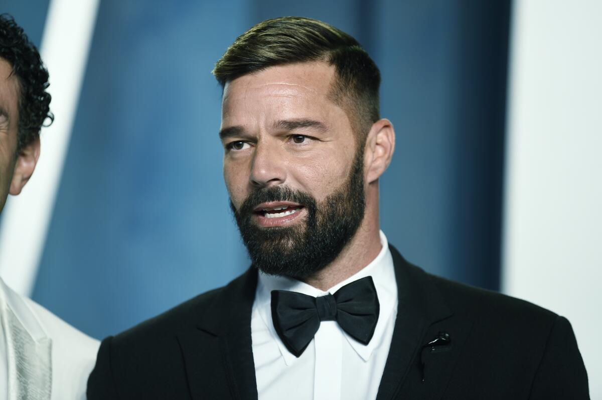 Ricky Martin posing in a black-and-white tuxedo