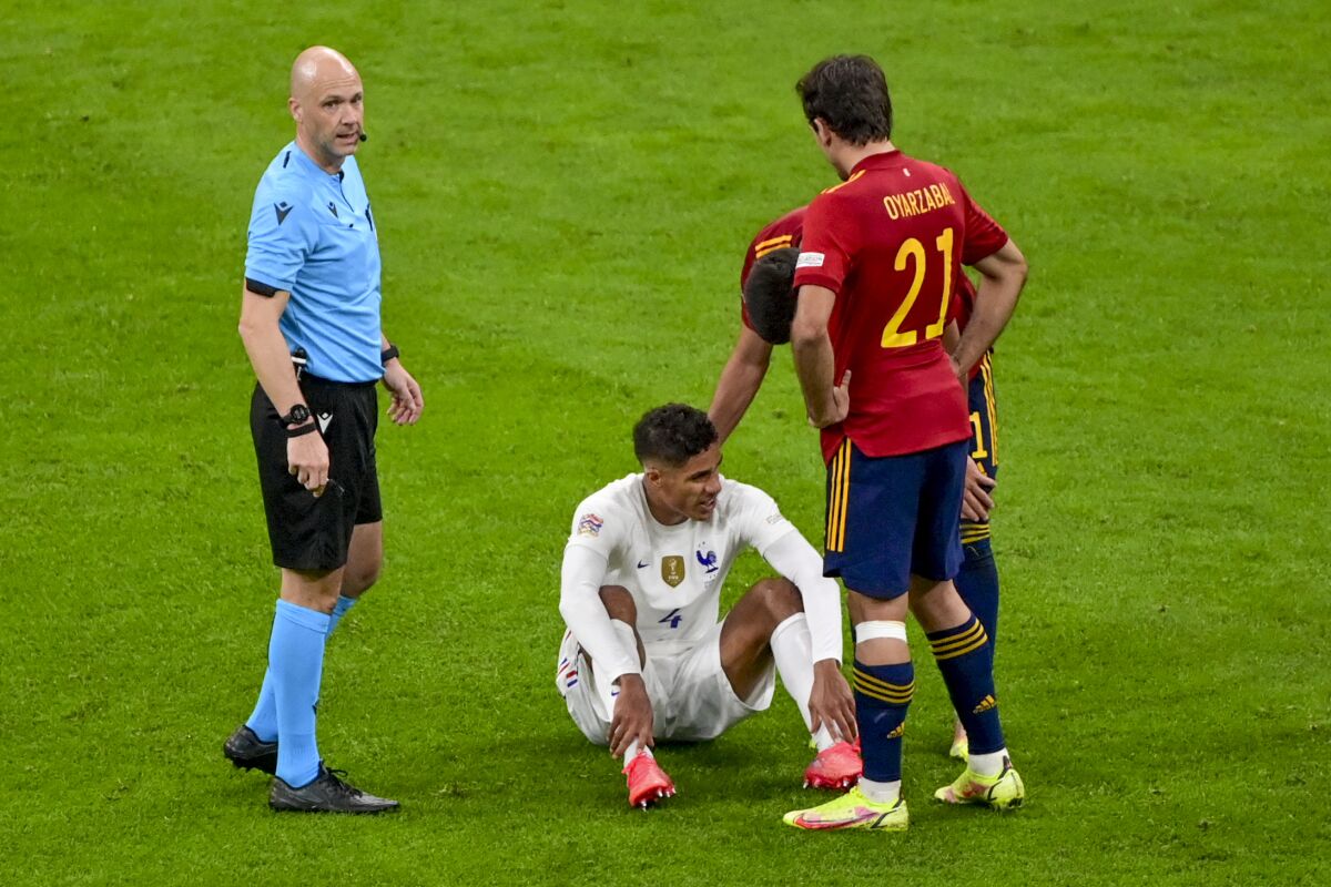 France's Raphael Varane sits on the pitch after an injury during the UEFA Nations League final soccer match between Spain and France at the San Siro stadium, in Milan, Italy, Sunday, Oct. 10, 2021. (Miguel Medina/Pool Photo via AP)