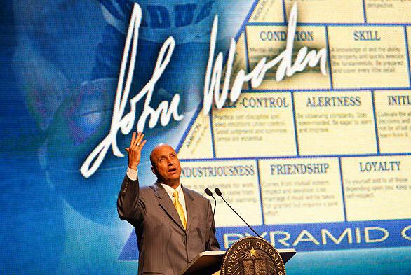 Pastor Dudley Rutherford, framed by the "Pyramid of Success," delivers his remarks during the memorial for former UCLA basketball coach John Wooden on Saturday at Pauley Pavilion.