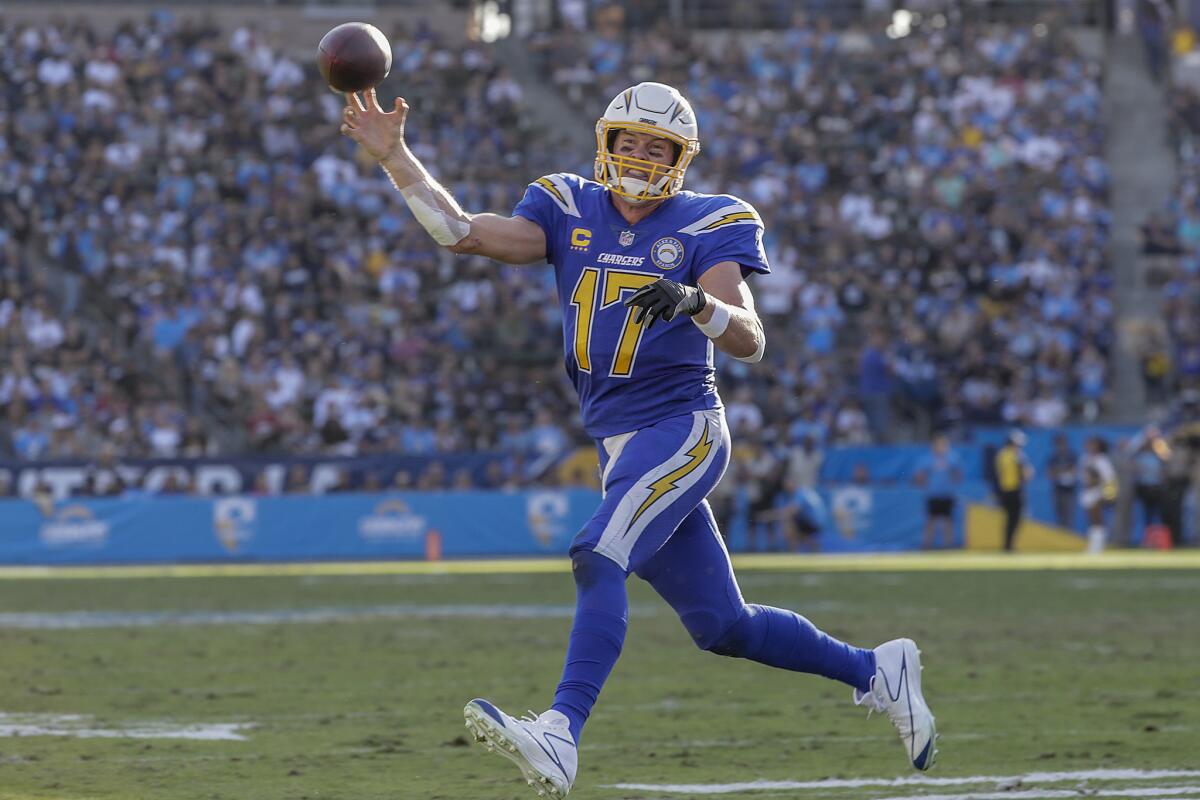 Chargers quarterback Philip Rivers rolls out to throw a four-yard touchdown pass to Keenan Allen in the third quarter against the Arizona Cardinals at StubHub Center on Sunday.