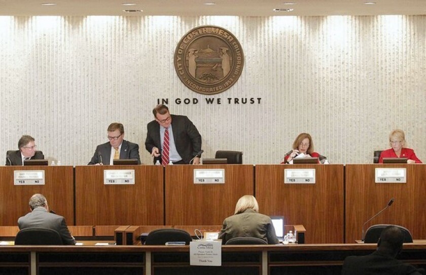 Jim Righeimer, center, takes his seat after being appointed mayor of Costa Mesa during Tuesday's council meeting.