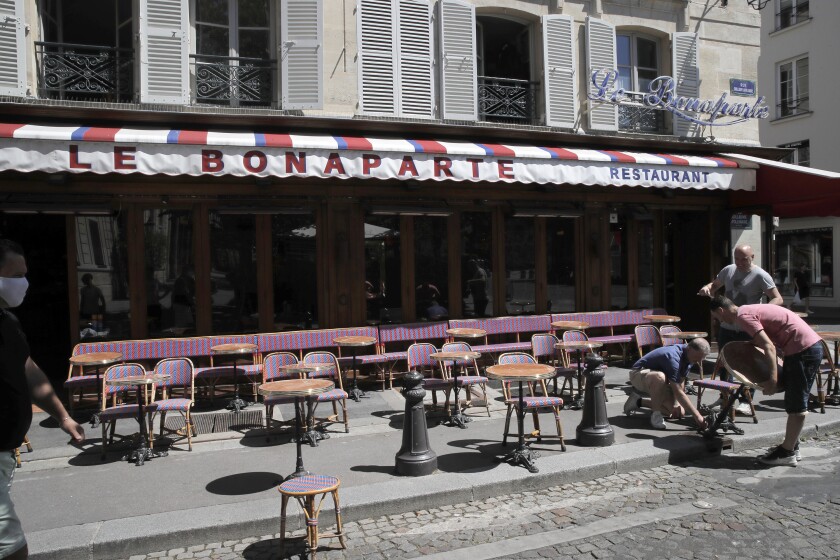 En esta imagen de archivo, tomada el 1 de junio de 2020, camareros preparan la terraza de un restaurante para respetar la distancia de seguridad, en París, mientras Francia levanta gradualmente su cuarentena por el coronavirus. (AP Foto/Christophe Ena, archivo)