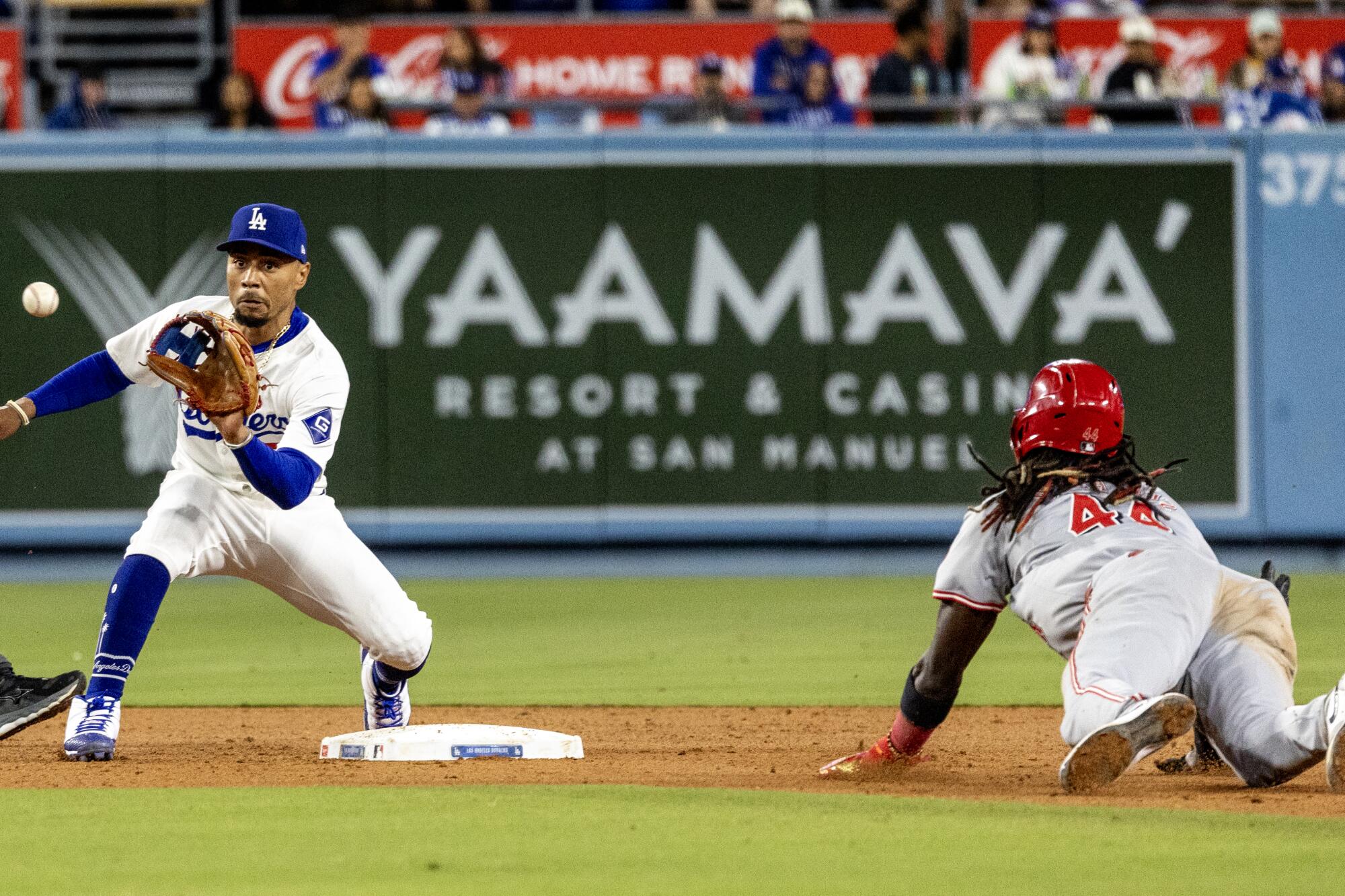 Dodgers shortstop Mookie Betts takes the throw from catcher Austin Barnes to tag out Reds shortstop Elly De La Cruz.