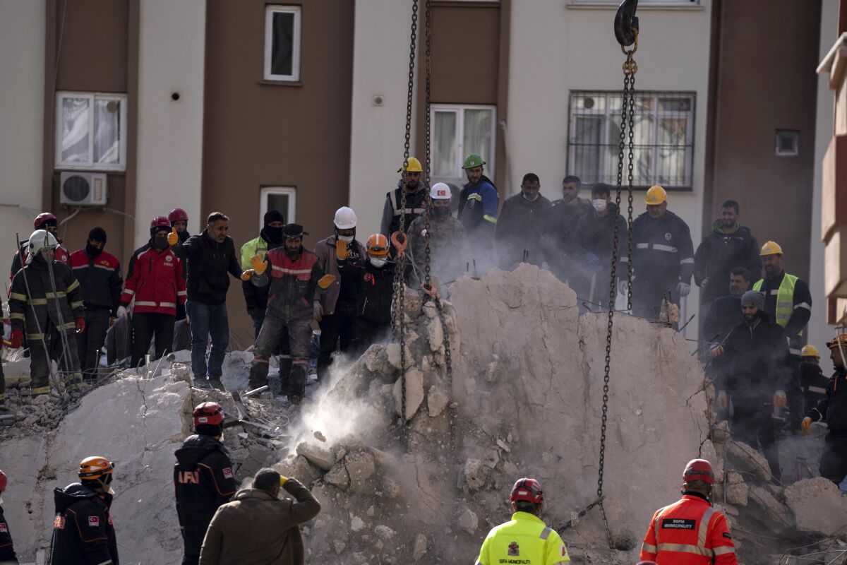 Firefighters and rescue teams search for people in a destroyed building, in Adana, southern Turkey, Wednesday, Feb. 8, 2023. Nearly two days after the magnitude 7.8 quake struck southeastern Turkey and northern Syria, thinly stretched rescue teams work to pull more people from the rubble of thousands of buildings. (AP Photo/Petros Giannakouris)