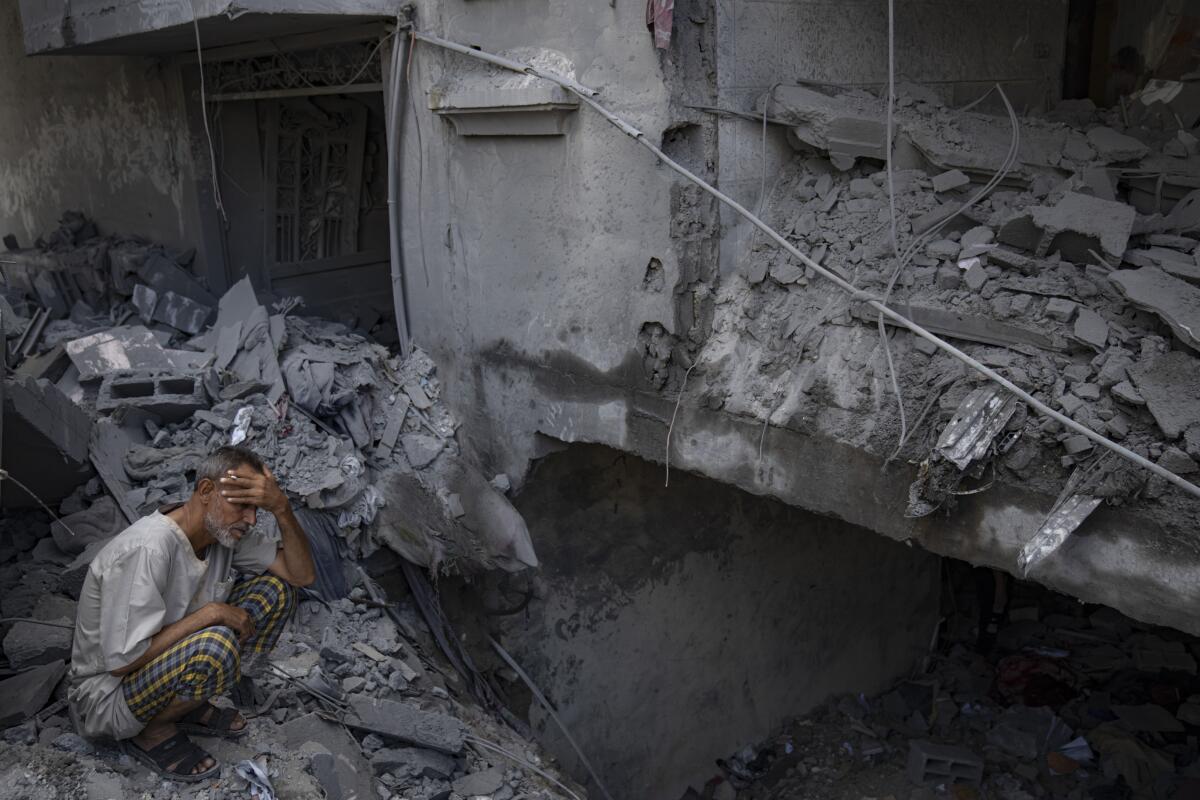 Un hombre sentado afuera del edificio donde vivía que fue destruido durante unos ataques israelíes 