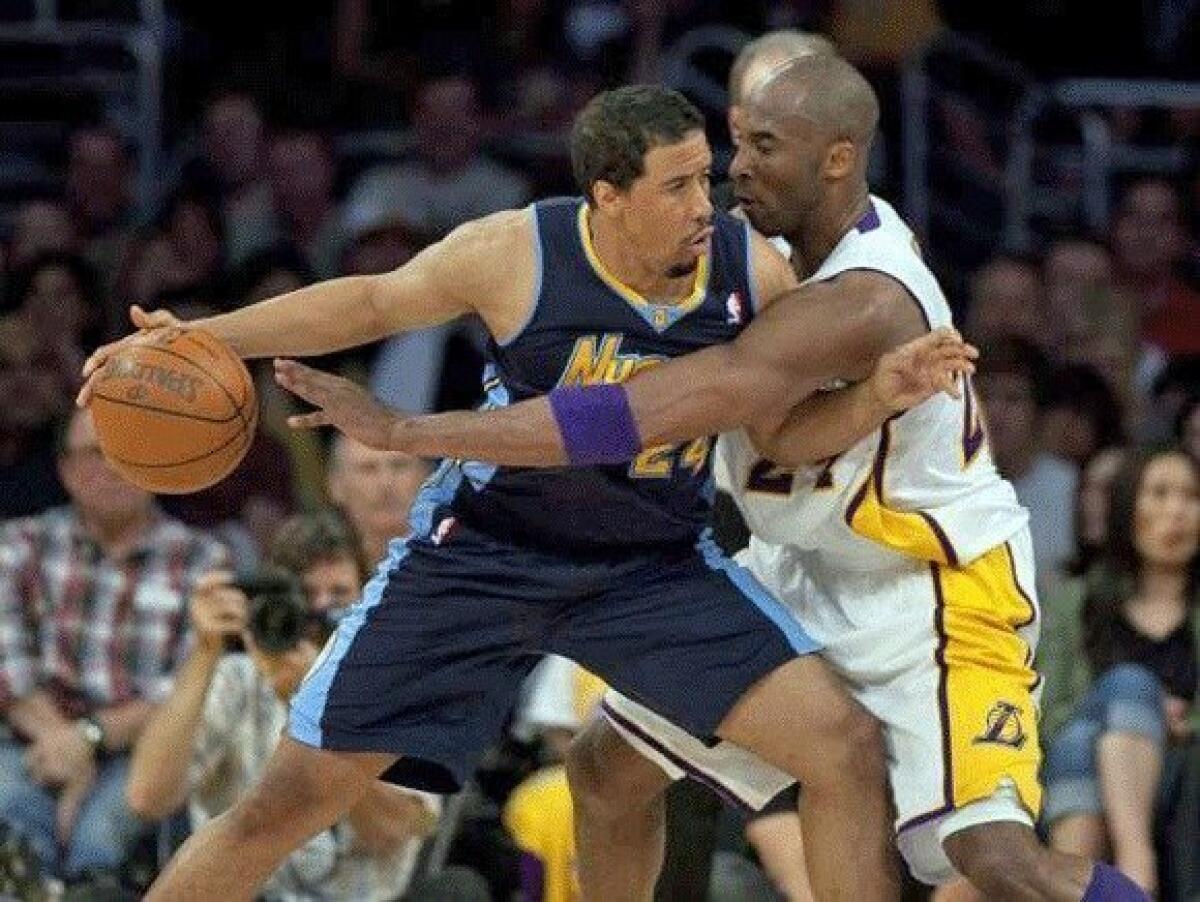 Lakers guard Kobe Bryant tries to disrupt the dribble of Nuggets point guard Andre Miller in the first half Sunday afternoon at Staples Center.