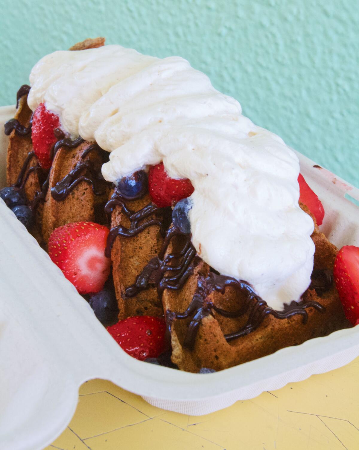 Buckwheat waffles under Earl Gray whipped cream, berries and chocolate drizzle from Kitchen Mouse