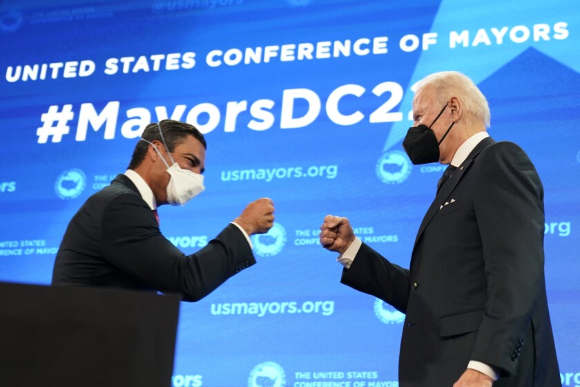 Mayor of Miami Francis Suarez, and president of U.S. Conference of Mayors, knocks knuckles with President Joe Biden after introducing him to speak at the U.S. Conference of Mayors' 90th Annual Winter Meeting at the Capitol Hilton in Washington, Friday, Jan. 21, 2022. (AP Photo/Andrew Harnik)