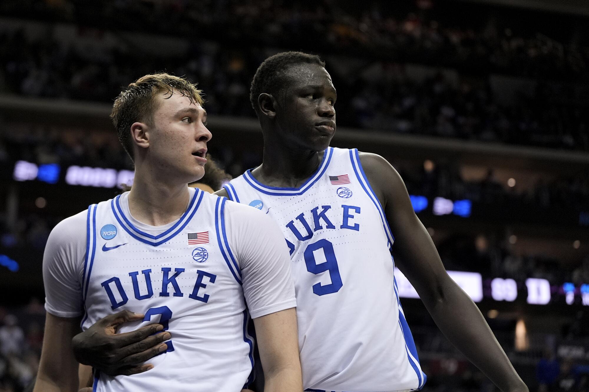 Duke center Khaman Maluach, right, wraps his right arm around teammate Cooper Flagg.