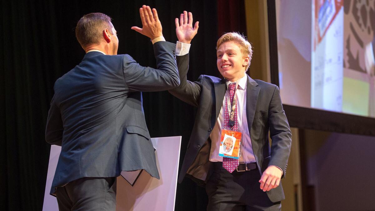 John Dumoulin, 17, of Virginia gets a high-five from Aaron Osmond, general manager at Certiport, after being named Excel 2016 champion.