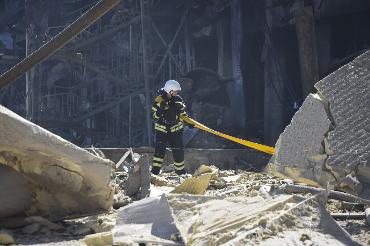 An Ukrainian firefighter works near a destroyed building on the outskirts of Odesa, Ukraine, Tuesday, May 10, 2022. The Ukrainian military said Russian forces fired seven missiles a day earlier from the air at the crucial Black Sea port of Odesa, hitting a shopping center and a warehouse. (AP Photo/Max Pshybyshevsky)
