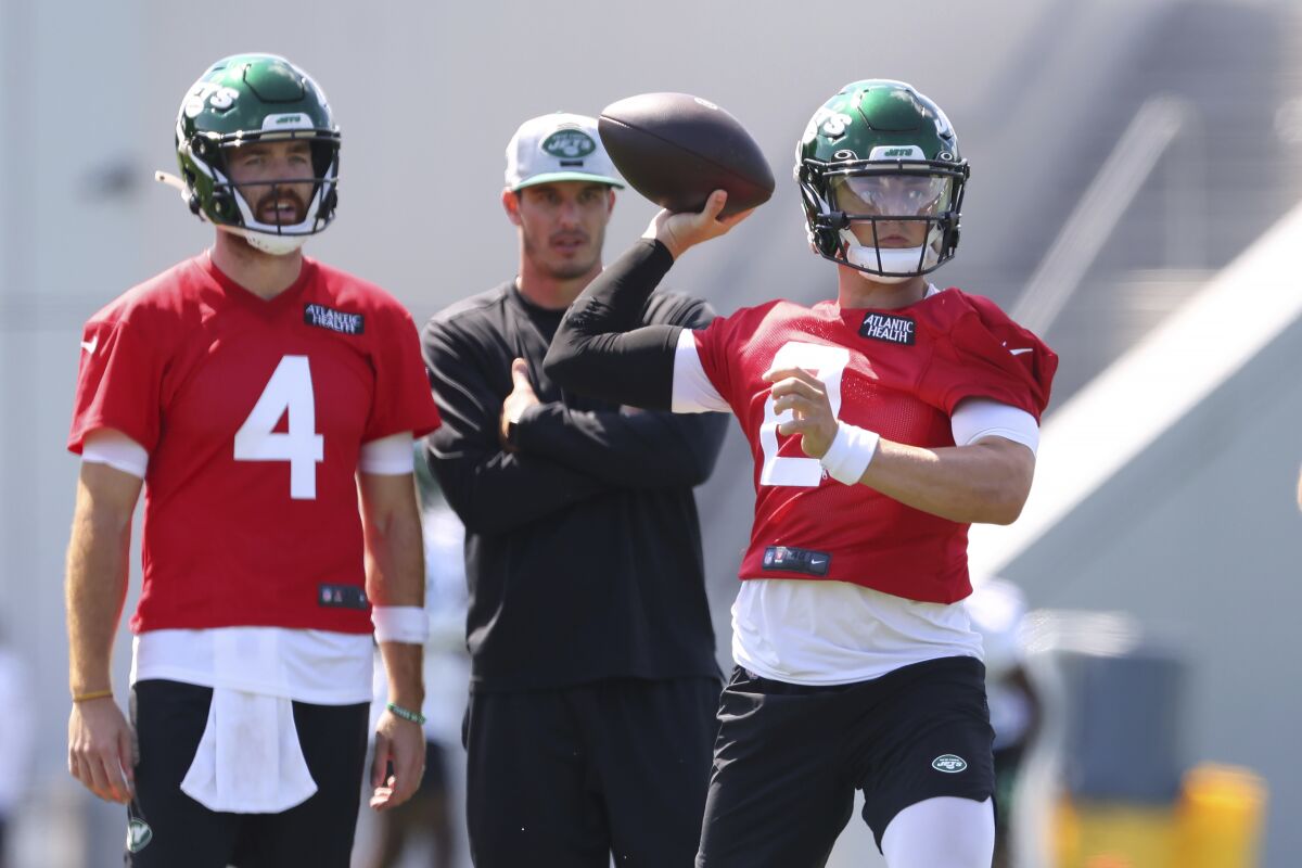 FILE - New York Jets quarterback Zach Wilson (2) looks to pass as James Morgan (4) and quarterbacks coach Rob Calabrese look on during practice at the team's NFL football training facility, Saturday, July. 31, 2021, in Florham Park, N.J. Rob Calabrese grew up rooting for the New York Jets, a fandom born somewhat out of necessity because it was everywhere he turned. Fast forward nearly 30 years, and Calabrese is one of his favorite NFL franchise's most important figures. (AP Photo/Rich Schultz, File)