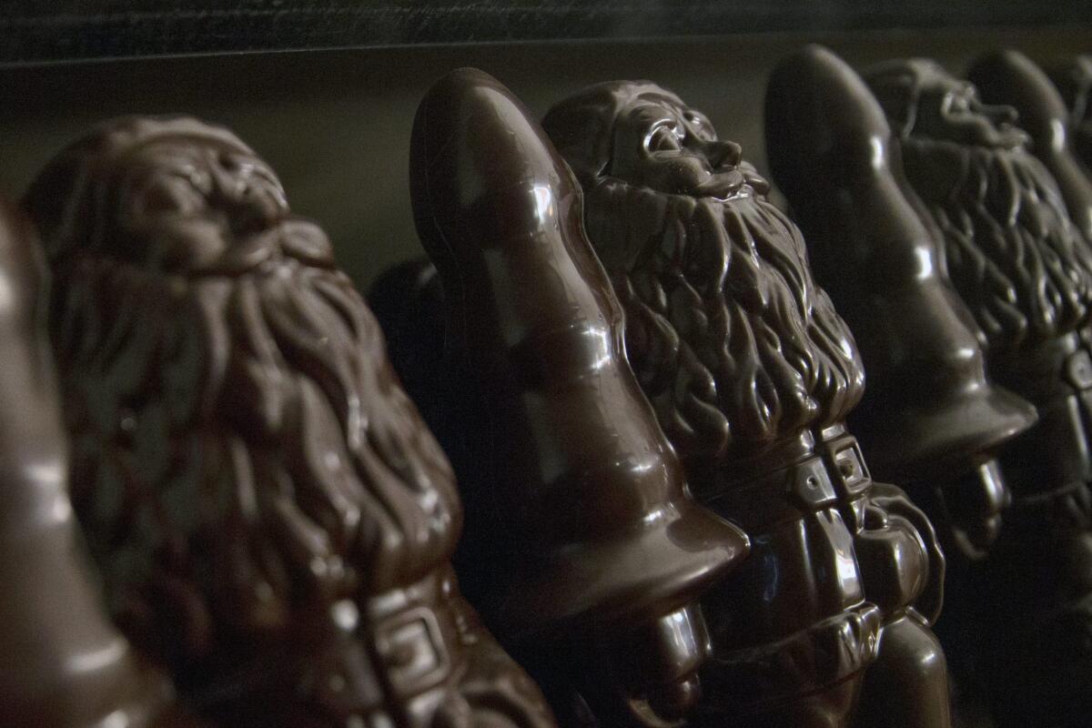 Artist Paul McCarthy's chocolate effigies of "Santa With Tree" are stacked on shelves at the artist's exhibition "Chocolate Factory" at La Monnaie de Paris.