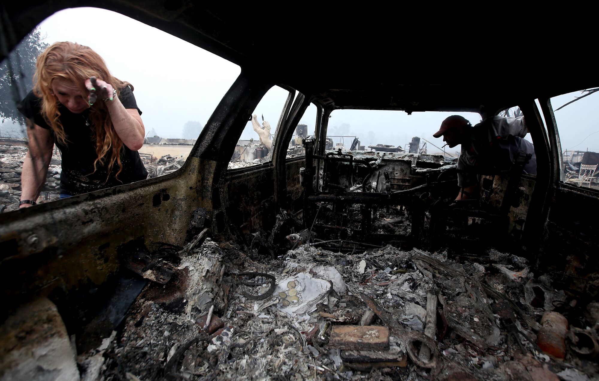 Sherri Marchetti-Perrault and James Benton embrace as they sift through the remains of their home near Yreka, Calif.