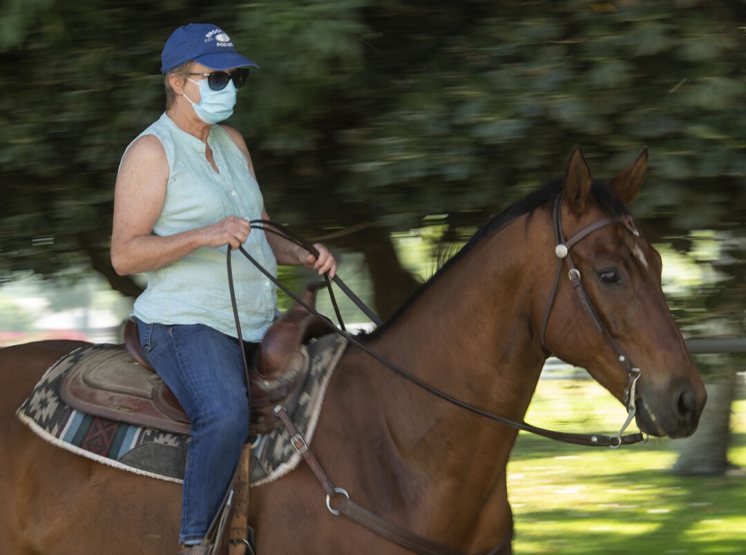 Sharron Enriquez of Eagle Rock rides her horse Bear along a trail in Burbank.